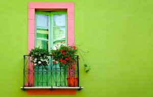 Фасад дома окрашен в яркий салатовый цвет