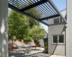 Металлический навес расположен между двумя постройками частного двора Металлический навес расположен между двумя постройками частного двора