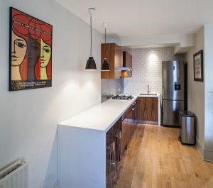 Рабочая столешница перетекает в барную стойку, которую можно использовать как обеденный стол Рабочая столешница перетекает в барную стойку, которую можно использовать как обеденный стол