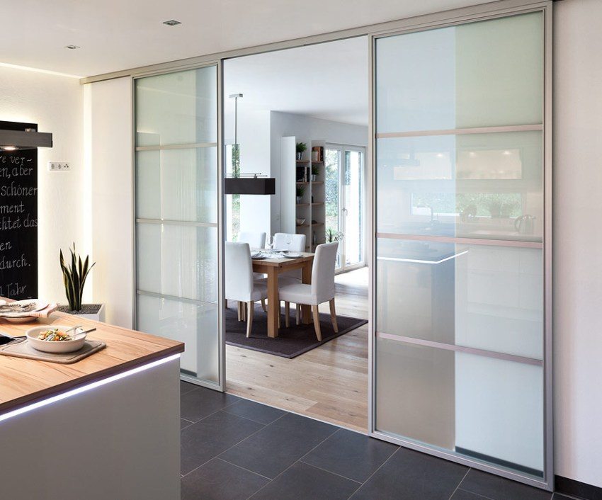 Двустворчатые двери-купе из полупрозрачного стекла между кухней и гостиной