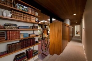 Книжные полки и шкаф-купе отделяют коридор от гостиной
