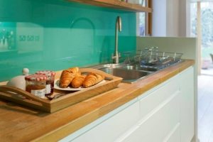 Панель из стекла защищает стену от капель воды и жира Панель из стекла защищает стену от капель воды и жира