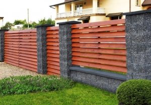 Комбинированный забор, выполненный из дерева и камня. Доски расположены "ёлочкой" Комбинированный забор, выполненный из дерева и камня. Доски расположены "ёлочкой"