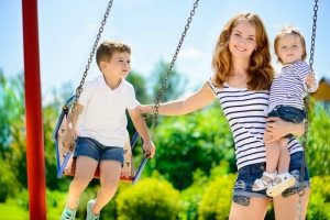 Детские качели с металлическим каркасом, покрашенные в яркие цвета Детские качели с металлическим каркасом, покрашенные в яркие цвета