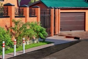 Кирпичный забор с элементами ковки вокруг загородного дома Кирпичный забор с элементами ковки вокруг загородного дома