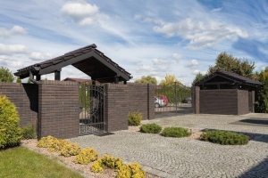 Территория частного дома окружена забором из кирпича Территория частного дома окружена забором из кирпича