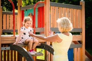 Детский игровой комплекс из древесины с горкой, установленный в саду Детский игровой комплекс из древесины с горкой, установленный в саду