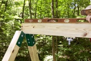 Рис. 3-5. Строительство деревянного игрового комплекса с горкой, качелями и песочницей в основании. Шаг 6: завершение монтажа рамы качелей Рис. 3-5. Строительство деревянного игрового комплекса с горкой, качелями и песочницей в основании. Шаг 6: завершение монтажа рамы качелей