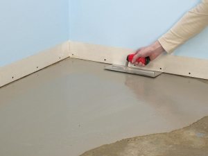 Нанесение выравнивающего слоя на бетонную стяжку