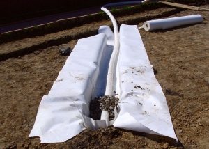 Процесс укладки на участке дренажных труб 110 мм с фильтром Процесс укладки на участке дренажных труб 110 мм с фильтром