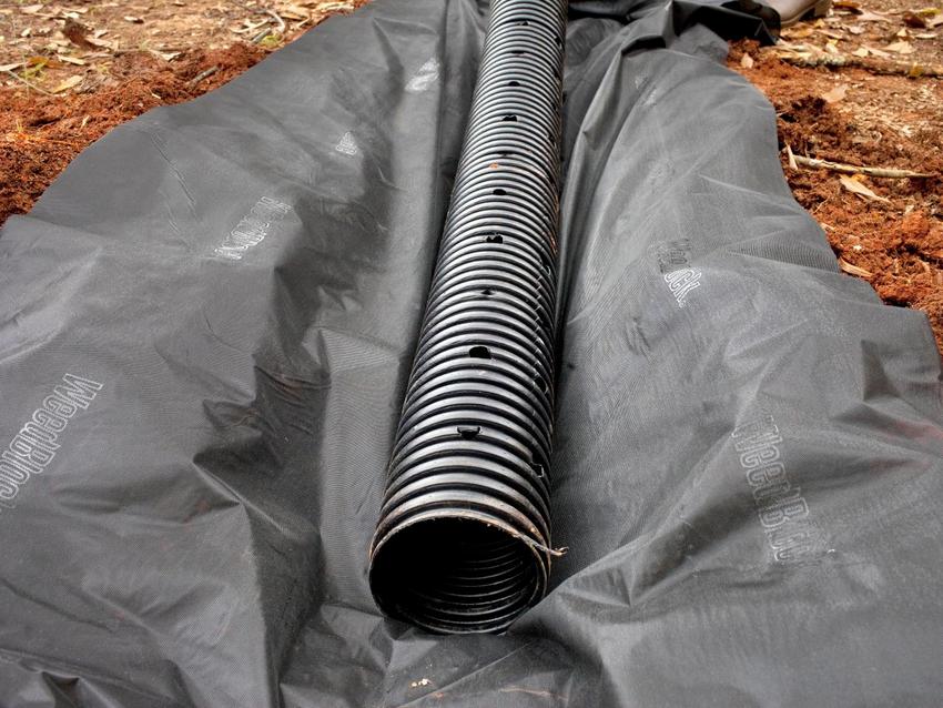 Монтаж системы отвода воды на земельном участке с использованием гофрированных пластиковых труб с перфорацией