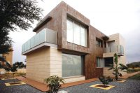 Фасад современного здания облицован керамогранитной плиткой различных цветов и размеров Фасад современного здания облицован керамогранитной плиткой различных цветов и размеров