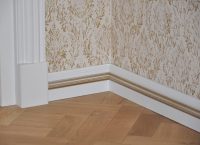 Напольный плинтус окрашен в два цвета - белый и золотой Напольный плинтус окрашен в два цвета - белый и золотой