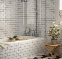 Укладка белой плитки среднего размера по всему периметру стен поможет визуально увеличить пространство ванной комнаты